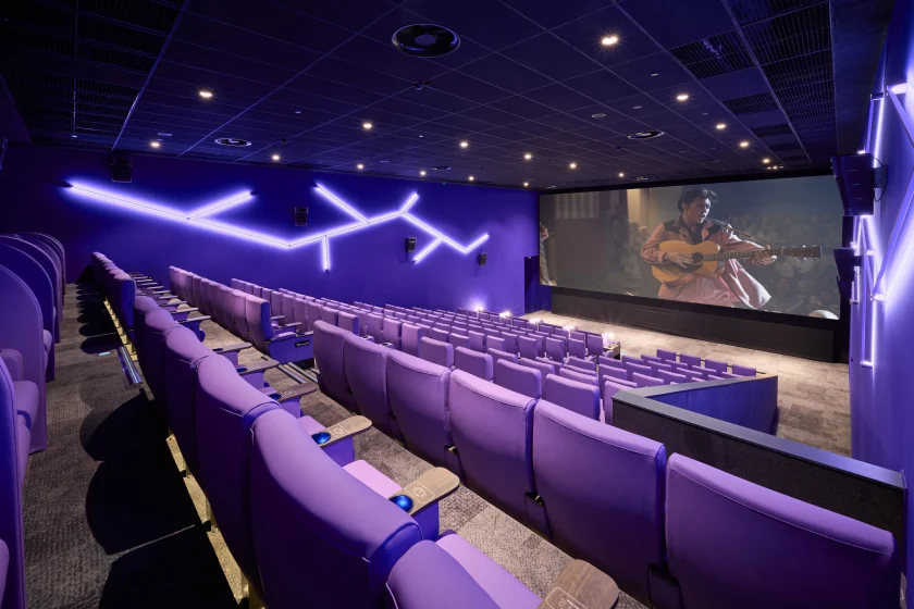 Unutrašnjost luksuzne dvorane kina CineStar u ZCentru (Zagreb) s crnim kožnim sjedalima, drvenim oblogama i modernom ukrasnom rasvjetom – projekt elektroinstalacija i automatizacije tvrtke SmartWay.